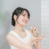 美容液を手に取り、笑顔で肌に塗布する若い女性