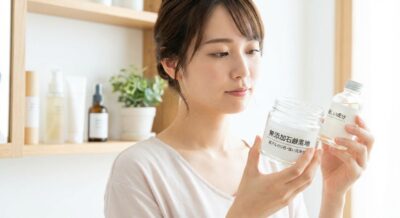 女性が「無添加石鹸素地」と書かれたジャーと「優しい成分」と書かれたボトルを手にしている